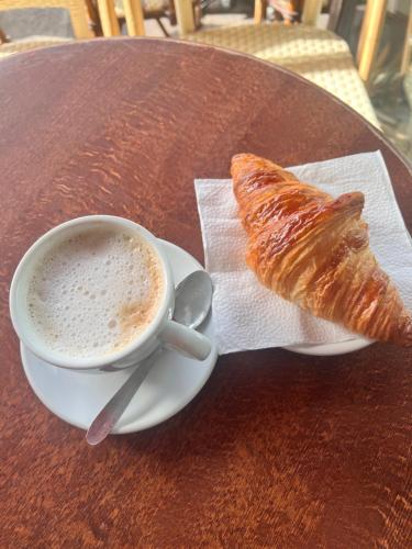 a cup of coffee and a pastry on a table at GS COTTAGE ON MALL ROAD in Shimla
