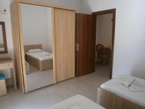 a room with a mirror and a bedroom with two beds at Blue Sky Taverna Apartments Kiki in Adelianos Kampos
