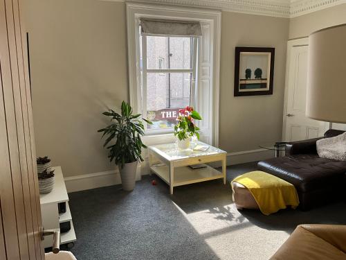 a living room with a couch and a table at The Old Post Office Double Room (town centre) in Carnoustie