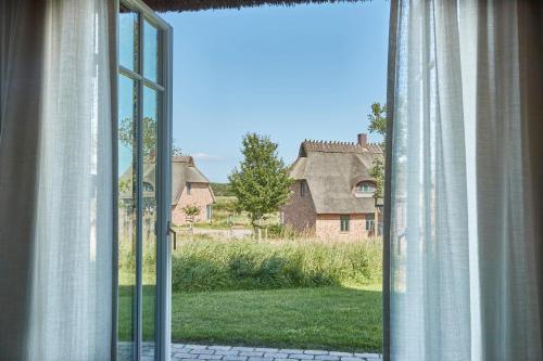 an open window with a view of a yard at Reetdorf Geltinger Birk Atelierhaus Salzwiese in Nieby