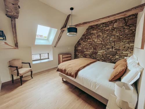 a bedroom with a stone wall and a bed at Domaine du Mimosa in Perros-Guirec