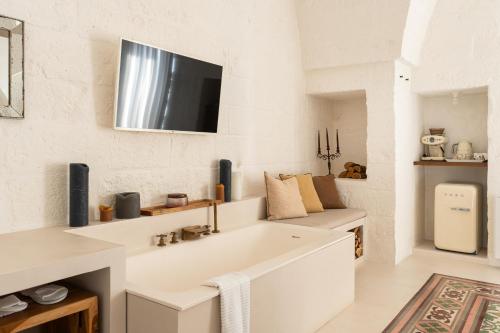 cocina blanca con fregadero y TV en la pared en AL PALAZZO La Dimora by Apulia Hospitality en Fasano