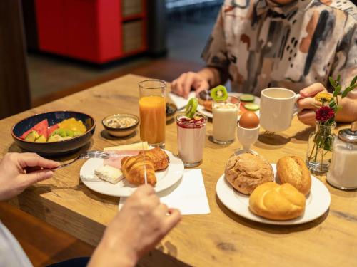 um grupo de pessoas sentadas à mesa com comida em ibis Gent Centrum Opera em Gent