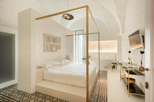 1 dormitorio con cama blanca y espejo en AL PALAZZO La Dimora by Apulia Hospitality, en Fasano