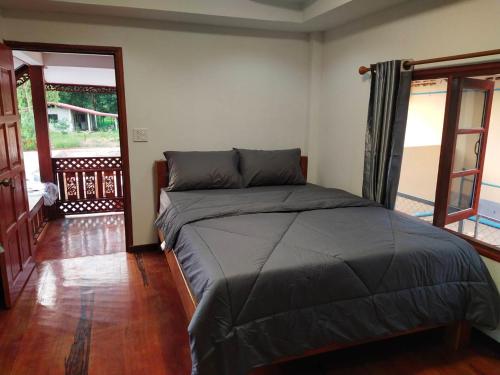 a bedroom with a bed in a room at Sappermpool Guest House เรือนคำขวัญ in Ban Dong Bang