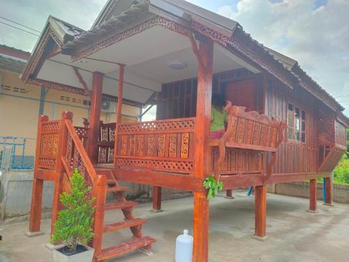 a small house with a porch and a person in it at Sappermpool Guest House เรือนคำขวัญ in Ban Dong Bang