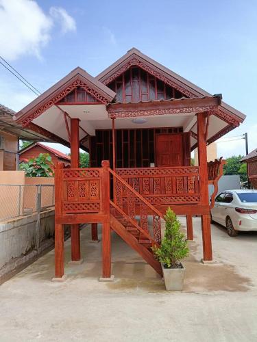 a large wooden bench in front of a building at Sappermpool Guest House เรือนคำขวัญ in Ban Dong Bang