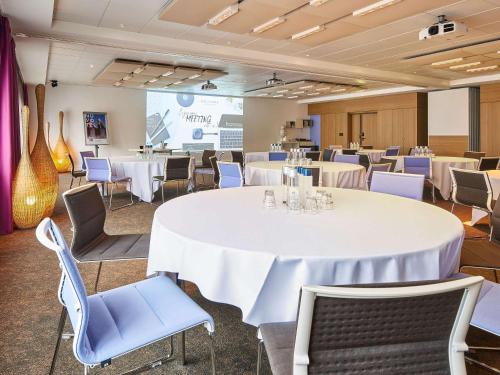 a conference room with a large white table and chairs at Novotel Paris Rueil Malmaison in Rueil-Malmaison