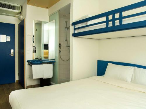 a bedroom with a bunk bed and a bathroom at Ibis Budget Graz City in Graz