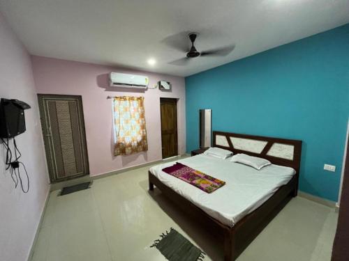 a bedroom with a bed with blue and pink walls at Goroomgo Beach Heaven Near Sea Beach Puri in Puri