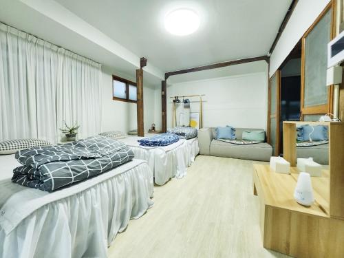 Daepung Stay في آندونغ: غرفة نوم بثلاث اسرة واريكة