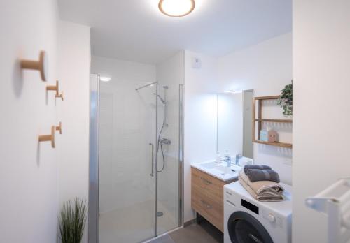 a bathroom with a shower and a washing machine at Cosy, lumineux, proche du centre-ville in Caen