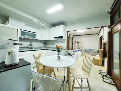 - une cuisine et une salle à manger avec une table et des chaises dans l'établissement Daepung Stay, à Andong
