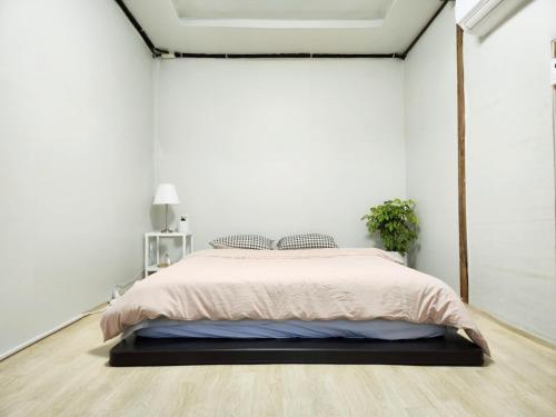 - une chambre avec un lit dans un mur blanc dans l'établissement Daepung Stay, à Andong