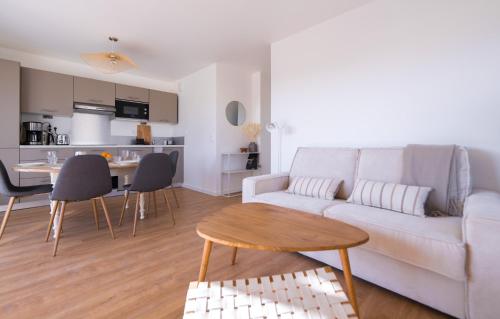 un salon avec un canapé blanc et une table dans l'établissement Cosy, lumineux, proche du centre-ville, à Caen