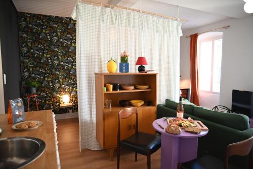 sala de estar con sofá verde y mesa en La Gaieté - Meilleurhote-Brioude, en Brioude