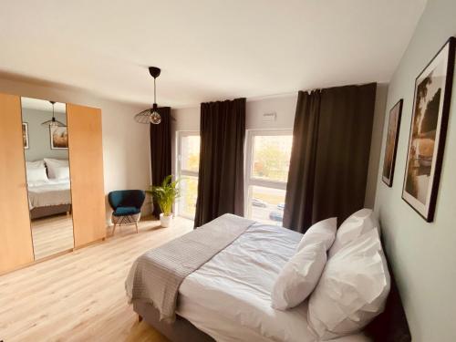 - une chambre avec un lit et une grande fenêtre dans l'établissement Mint House Apartment, à Varsovie