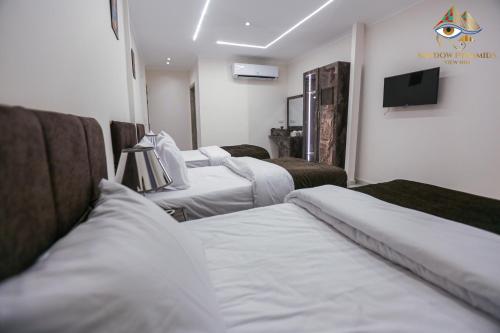 a hospital room with three beds and a flat screen tv at Shadow Pyramids Suites and Jacuzzi in Cairo