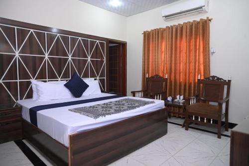 sypialnia z dużym łóżkiem i krzesłem w obiekcie Hotel Serina Inn w Kalar Goth