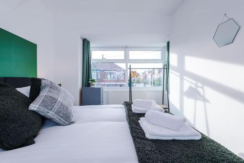 a bedroom with a bed with two towels on it at Cosy 3-Bedroom House Near City Centre with Free Parking in York