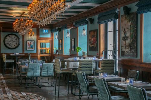 a dining room with tables and chairs and a clock at Best Western Moores Central Hotel in St Peter Port