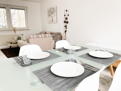 een eetkamer met een tafel met witte borden erop bij 1-4 Pers. Moderne 2-Etagen-Wohnung - nur 0,3 km vom Zentrum in Remscheid