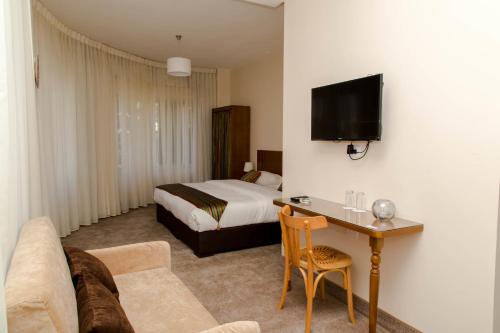 una camera d'albergo con letto e tavolo con divano di Antika Amman Hotel ad Amman