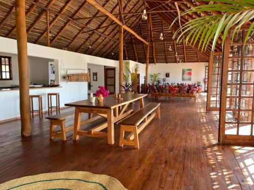 a dining area with a table and benches in a room at umbila:Barra in Inhambane