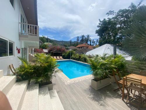 a backyard with a swimming pool and a wooden deck at New Seahorse Residence in Amphoe Koh Samui