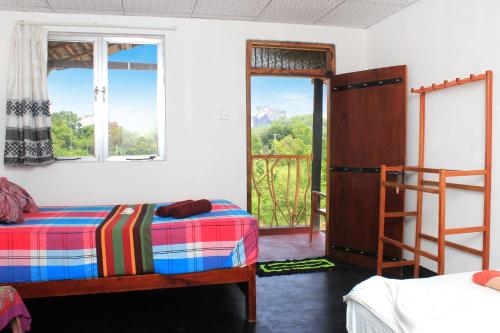 a bedroom with two bunk beds and a balcony at Sigiri Gayani Home Stay in Sigiriya