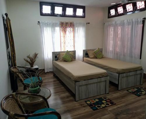 a living room with two beds and a window at Globetrotters homestay in Jorhāt