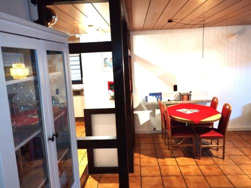 une cuisine et une salle à manger avec une table et des chaises rouges dans l'établissement Ferienwohnung Jette, à Oestrich-Winkel