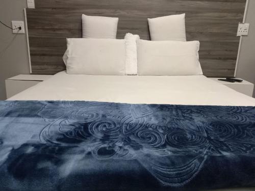 ein Bett mit einer blauen und weißen Decke drauf in der Unterkunft Executive Guest House Randfontein in Randfontein
