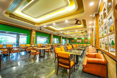 a restaurant with tables and chairs in a room at Mayfair Oasis Resort & Convention in Jhārsuguda