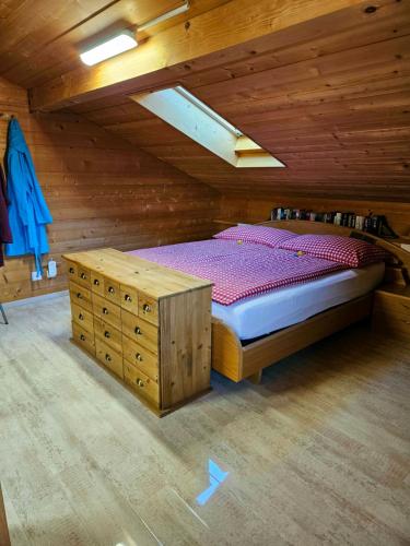 1 dormitorio con 1 cama en una cabaña de madera en Gemütliche FeWo mit Sauna inmitten der Berge, en Meiringen