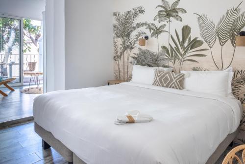 a bedroom with a large white bed with a tray on it at Hôtel La Villa Juan Beach in Juan-les-Pins