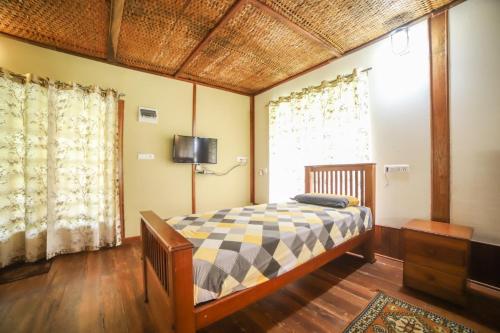 1 dormitorio con 1 cama y TV en la pared en Coorg coffee estate 3 bedroom villa with open balcony en Napoklu