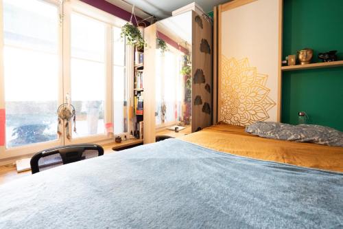 ein Schlafzimmer mit einem großen Bett und einer grünen Wand in der Unterkunft L'Exotique - T2 Proche Paris & Bois de Vincennes in Saint-Mandé