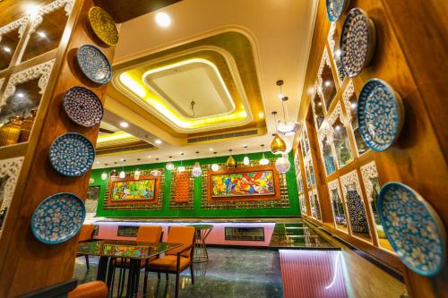 a restaurant with tables and chairs and plates on the wall at Mayfair Oasis Resort & Convention in Jhārsuguda