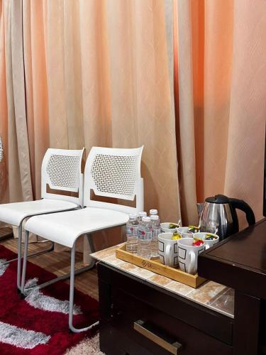 two white chairs sitting next to a table with drinks at S8 Boutique Hotel near KLIA 1 & KLIA 2 in Sepang