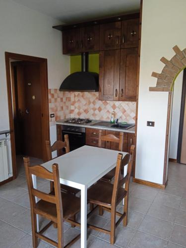 cocina con mesa blanca y armarios de madera en Da Vale e Teo, en Legnano