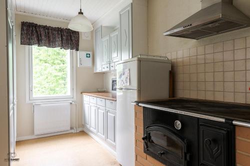 een keuken met een koelkast en een raam bij Honkaranta in Jämijärvi