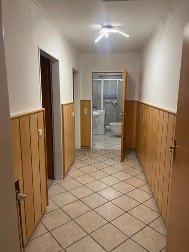a hallway of a bathroom with a toilet and a tub at Pharos zur Seeve in Seevetal