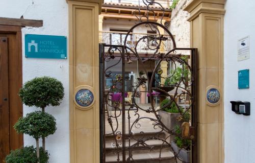 Hotel Poeta Jorge Manrique في سيغورا دي لا سييرا: باب مع بوابة حديد مفروشة بالنباتات