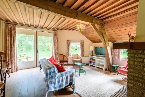 a living room with a couch and a tv at Prachtig vrijstaand familiehuis op groot perceel in Scherpenzeel