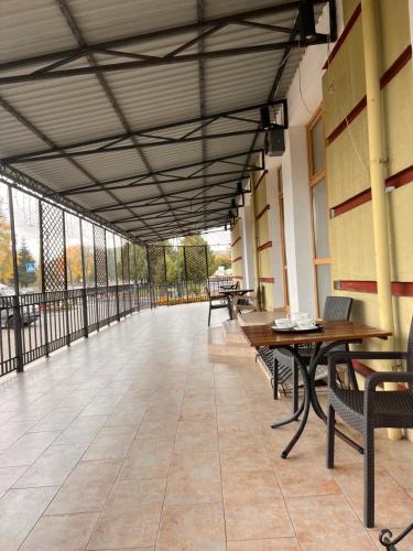 an empty hallway with tables and benches on a building at Бобри плюс in Novovolynsʼk