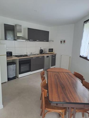 a large kitchen with a wooden table and chairs at Bel appartement indépendant et lumineux in Bartrés