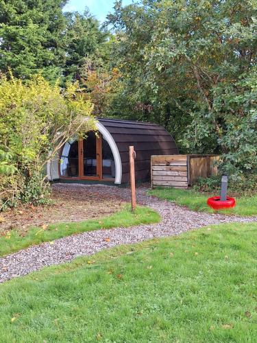 a small house with a red frisbee in the grass at Priory Glamping Pods and Guest accommodation in Killarney