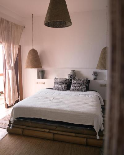 a bedroom with a bed with pillows on it at La Beach Penida in Nusa Penida