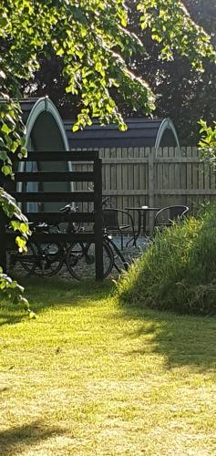 a park bench next to a wooden fence at Priory Glamping Pods and Guest accommodation in Killarney